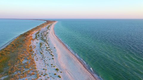 Shooting from a drone flying over a long sandy spit. Location place Kinburn peninsula, Black sea, Ukraine, Europe. Cinematic aerial shot. Discover the beauty of earth. Filmed in 4k, drone video.