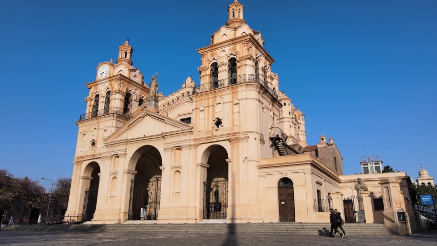 Dolly out shot of a Cathedral of Cordoba, Our Lady of the Assumption with mid century architectural design, slowly reveals lamp pose and contemporary sign in the foreground at San Martin Plaza.