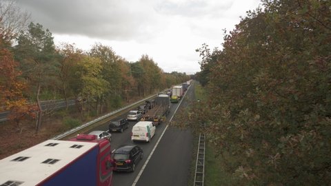 Heavy Traffic At A28 Motorway Amidst The Trees During Autumn Season. Veluwe, Gelderland, Netherlands. static shot