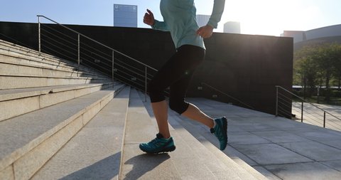 Fitness sports woman running up stairs in city, slow motion