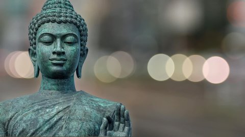 Buddha's face on green nature tree bokeh background.