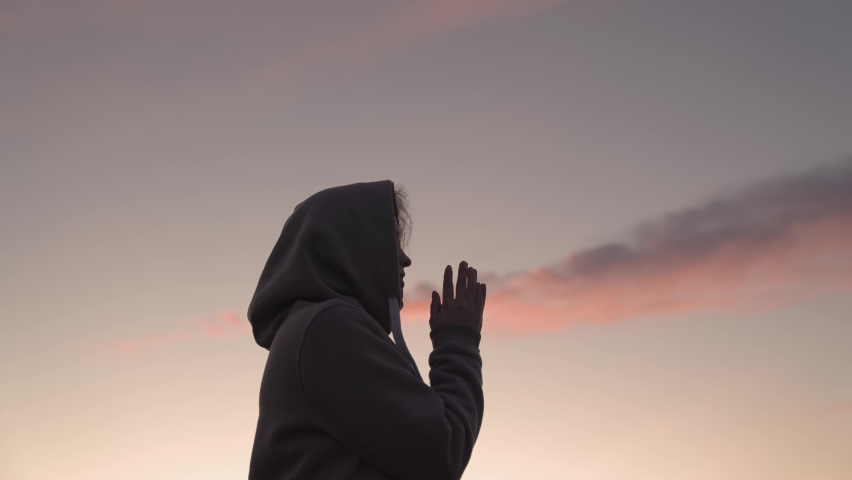 Girl praying on a pink sky background, believe in good good, ask for help, dream looking up, motivation inspiration outdoors, woman thinks meditating, wanderlust concept, heavenly light