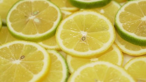 Juicy Lemon Slices, Macro. Sliced Lemon Lime Pieces Rotate. Citrus Fruits, Isolated. Background from Lemons Limes Lolek, Halves. Healthy Vegan Food and Vitamin C for the Immune System.