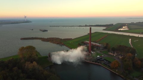Steam rising up from the old Steam Pumping Station in Lemmer, Friesland, during sunrise. Drone view from above.
