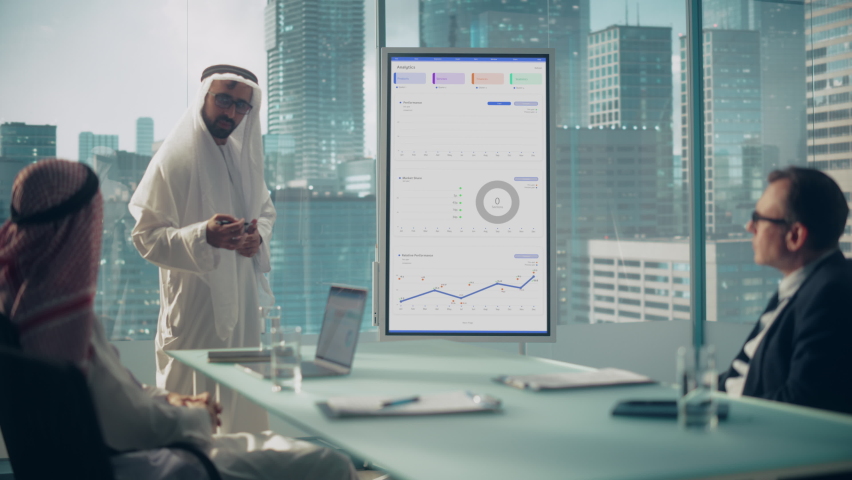 Emirati Businessman Holds Meeting Presentation for International Business Partners. Manager Uses Whiteboard with Growth Analysis, Charts, Statistics and Data. Saudi, Emirati, Arab Office Concept. Royalty-Free Stock Footage #1082792197