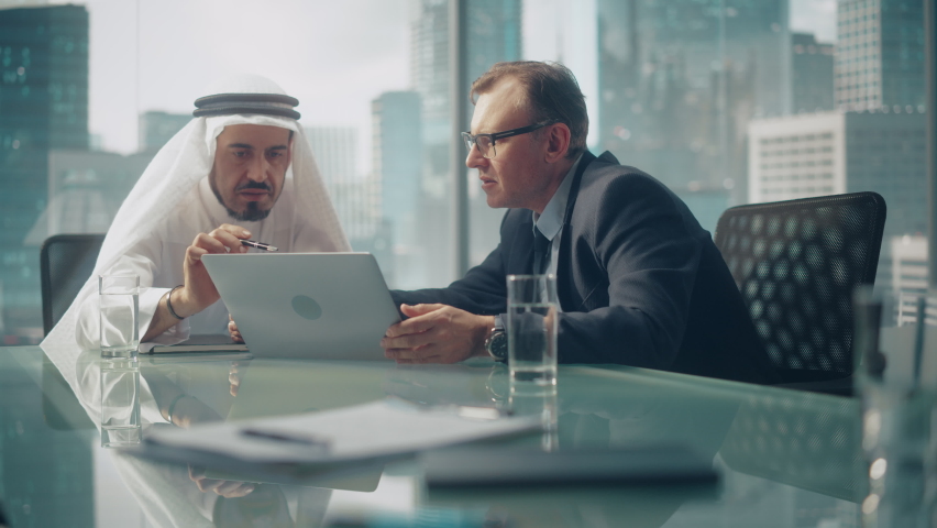 International Business Consultant Advices on Diversification of Investment Portfolio to Successful Arab Company Owner. Multicultural Meeting in Modern Office Between American and Emirati Businessman. Royalty-Free Stock Footage #1082792233