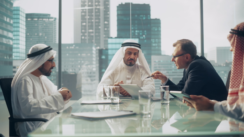 International Business Consultant Advices on Diversification of Investment Portfolio to Successful Arab Company Owners. Multicultural Meeting in Modern Office Between European and Emirati Businessman Royalty-Free Stock Footage #1082792263