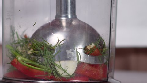 izmelblenye submersible blender vegetables to make sauce close-up slow motion