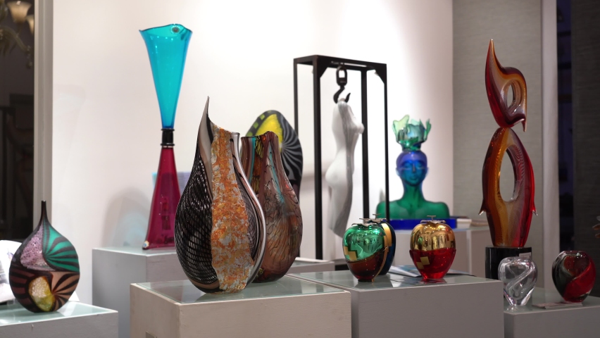 Italy venice November 2021 Lady woman tourist shopping for colorful decorated objects made of a famous murano glass in a shop window in Venice