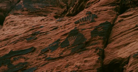 Weathered petroglyph panel with worn desert varnish depicts what may have been hands or feet, a common motif found in rock art across the southwest. 