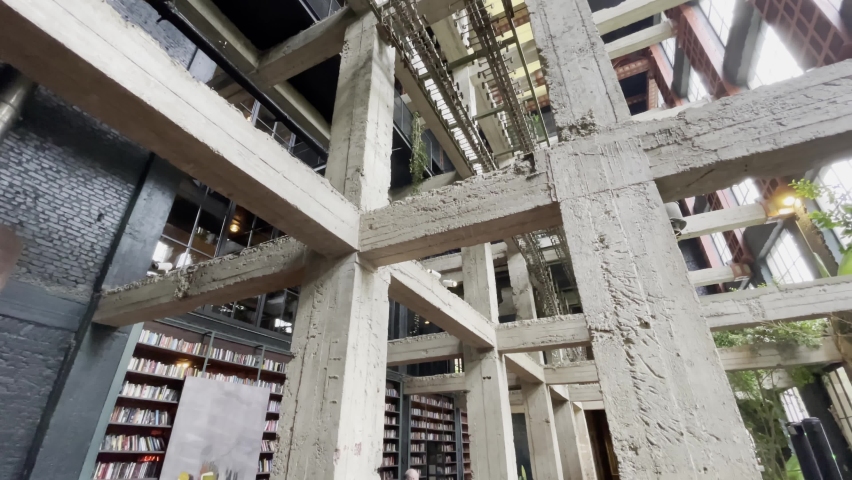 From below concrete beams and glass path located inside sunlit contemporary building in daytime