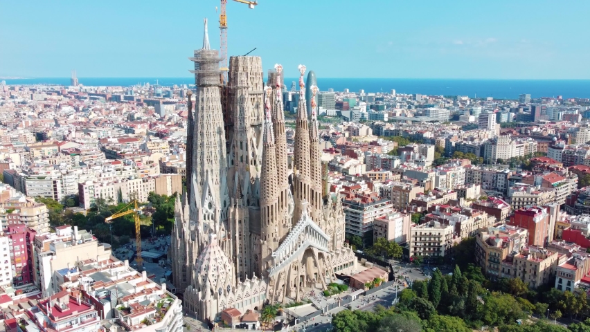 Barcelona's La Sagrada Familia. Construction works and cranes and a great landscape with the sea in the background Royalty-Free Stock Footage #1082812480