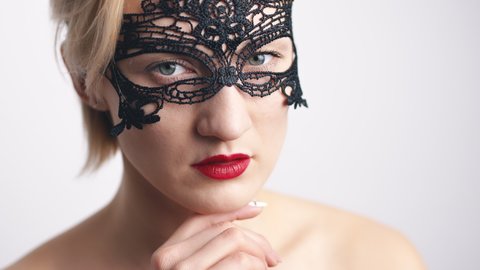Woman In Black Lace Mask And Red Lipstick Posing In White Background. - close up