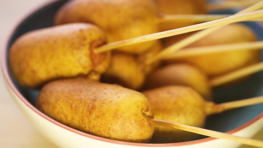 Corn dog prepared with sausage and wheat dough with the addition of corn flour, close up Royalty-Free Stock Footage #1082816017