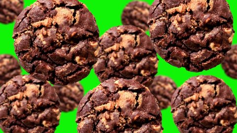 Flying Dark Delicious Chocolate Chip Cookies of different diameters on the green screen on isolated background. Moving background pattern. Animated Background.High quality 4k Christmas sweets footage