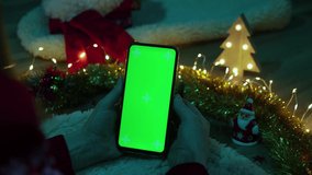 Green screen pnone in hands. Christmas concept