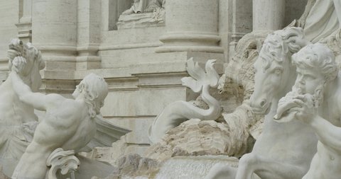 Panning left shot: Detail of a sculpture of the Trevi fountain in Rome. Slow motion 50fps 4k