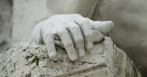 Focus priority: Detail of the hand of a sculpture of the Fountain of the four rivers in Piazza Navona Rome Italy. Hand of the sculpture close-up. Slow motion 50fps 4k