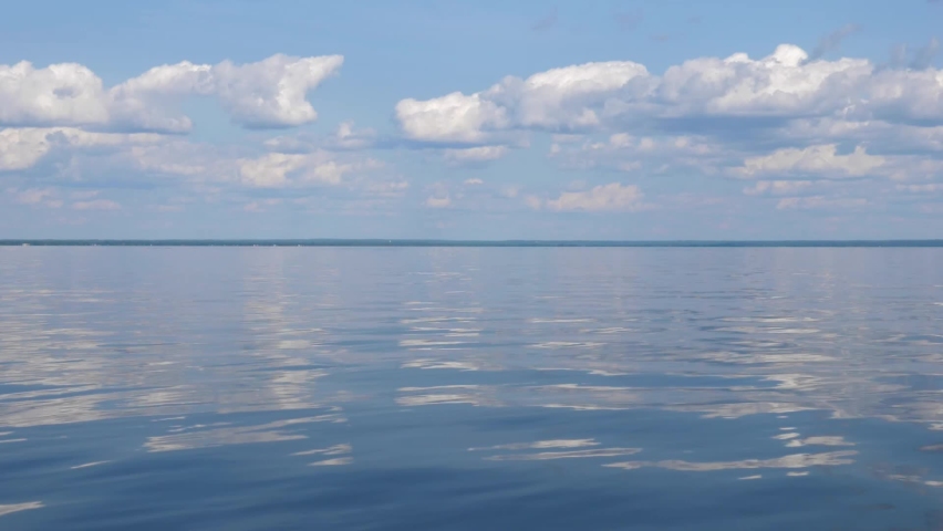 Slow motion cruising on Lake Nipissing, North Bay, Ontario, Canada. Beautiful calm surface with white clouds reflecting in the water.