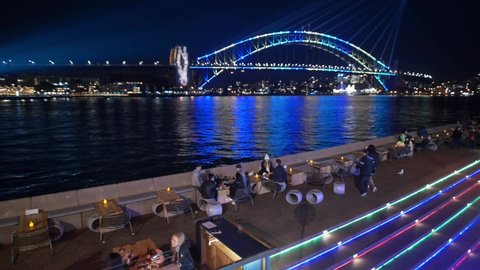 SYDNEY, NSW, AUSTRALIA. JUNE 11 2019. Waiting staff serve drinks by Sydney harbour, during Vivid light festival.
