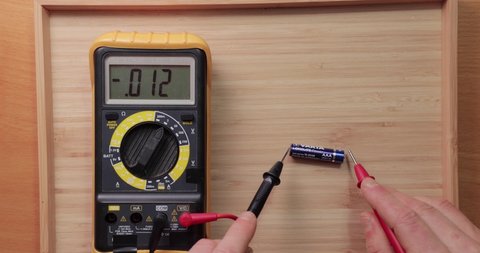 Budapest, Hungary - Circa 2021: Testing AAA battery cell from Duracell with digital multimeter tool, voltage check showing low value, battery is used and discharged