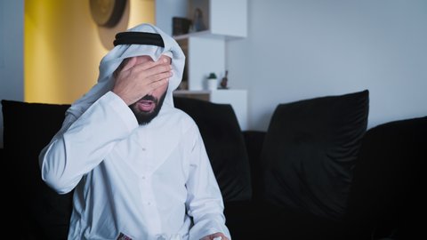 Arab man wearing white kandura sick and coughing 