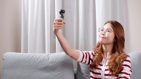 Girl doing vlog in her house holding camera in hand.