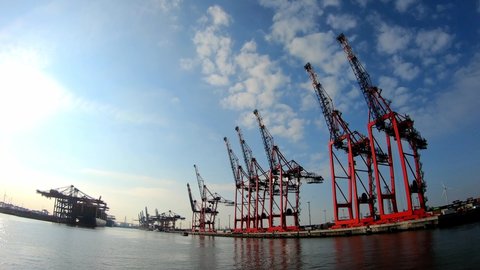 Timelapse shot of the Elbe river, huge harbour cranes and boat in Hamburg, Germany 