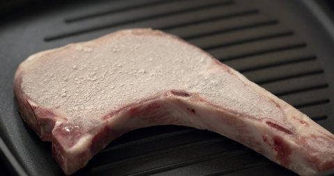 Thawed frozen T-Bone steak isolated on the frying pan.
