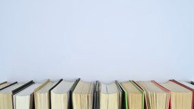 6k Pile of hardcovered book in different colors move on bookshelf with empty space for text. Stop motion flat lay - Powered by Shutterstock - Get 15% off with code: PIKWIZARD15