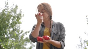 Smiling woman smelling fresh ripe tomatoes - Powered by Shutterstock - Get 15% off with code: PIKWIZARD15