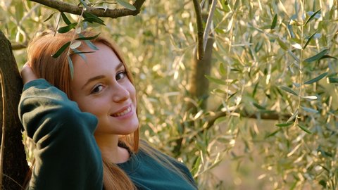 Young woman relaxing leaning on olive tree