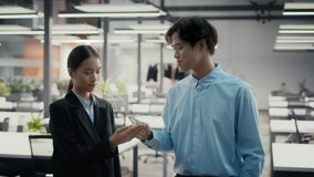 Covid-19 Prevention. Asian Female And Male Colleagues Sanitizing Hands, Businessman Spraying Sanitizer On Businesswoman's Hands Caring For Health During Pandemic Standing In Office - Powered by Shutterstock - Get 15% off with code: PIKWIZARD15