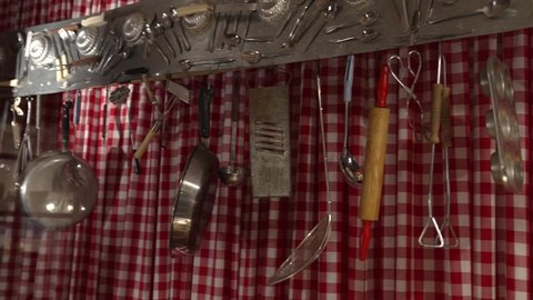 This panning video shows kitchen cooking tools hanging against a red and white checkered background.