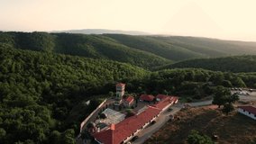 Aerial of bulgarian monastery building located in the middle of forest area. Ancient building with unique design. Drone video in 4K. Gigintsi Monastery
