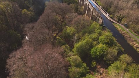 Low level aerial footage over Avon Aqueduct within Muiravonside Country Park which carries the Union Canal over the River Avon, near Linlithgow, Scotland.