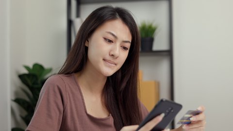 Stressed young asian woman holding smartphone and credit card in put the payment but Not enough money on credit card to pay