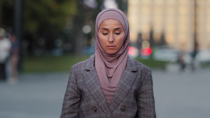 Portrait of muslim scared woman aggressive worried sad stressful girl in hijab stands in city looking at camera cardboard sign banner no protesting denying disagreement, discrimination racism concept Royalty-Free Stock Footage #1082856844