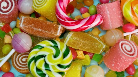 Lollipops, traditional cane candy, Orange and lemon marmalade, mixed multi-colored candies are spinning. Sweets for children.