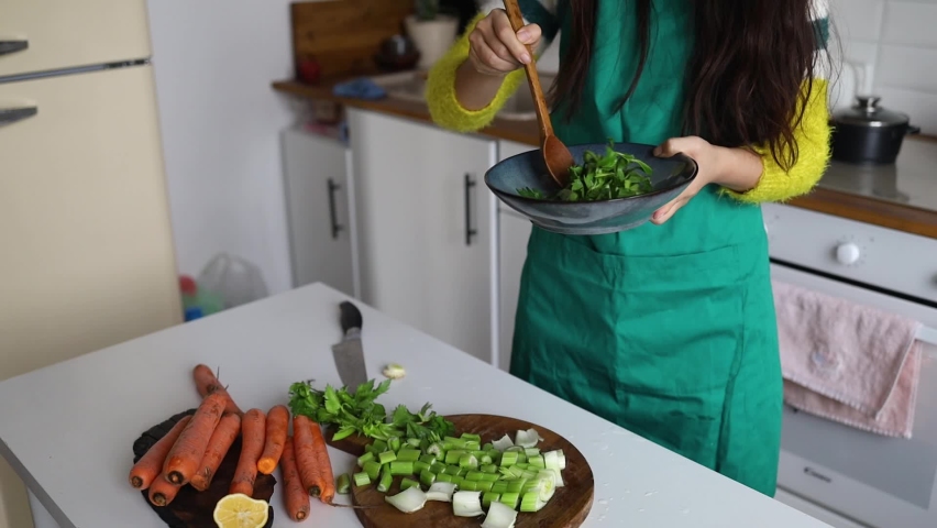 elegant asian chinese woman eating healthy salad at home kitchen. girl tasting vegetarian food at modern apartment.