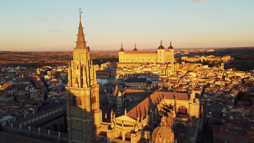 Dramatic aerial drone footage of the sunset over the Tolede, or Toledo, medieval old town with the cathedral and the Alcazar in the background near Madrid in Spain