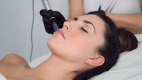 Video of cosmetologist making mesotherapy injection with dermapen on face for rejuvenation on the spa center.