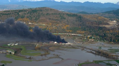 Burning Storage Yard Surrounded By Flood Plains In British Columbia, Canada. State Of Emergency Due To Catastrophic Flooding. aerial