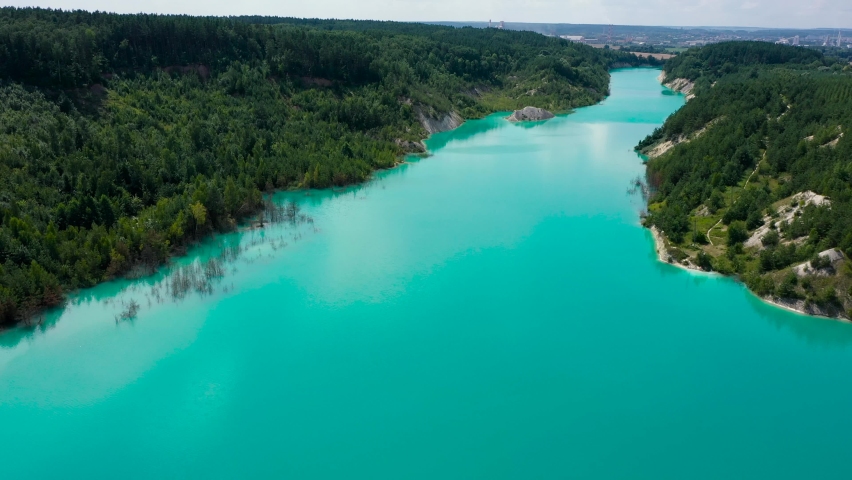 Drone view of open cast mine. Earthmoving work in open pit mining. Turquoise background of the water in chalk quarry. Industrial landscape. Aerial view Royalty-Free Stock Footage #1082868262