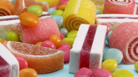 Soft focus Orange and lemon marmalade, vanilla marshmallow, mixed multi-colored candies are spinning. Sweets for children