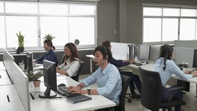 Call center is tired, young adult employee working with headset stretch while working hard, Customer support operator team feeling exhausted and yawning in office, Helpdesk customer services agent - Powered by Shutterstock - Get 15% off with code: PIKWIZARD15