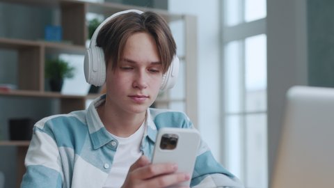 Young Man in Headphones Listening to Music at Home Close up. Attractive Teenager Smart Guy Relaxing at Song Sound on Audio Phone. Handsome Teen Male Student Sing Leisure Recreation at Favorite Music