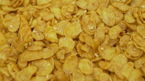 Healthy Honey Corn Flakes, Macro. Cereal with Honey for a Healthy Breakfast, Spinning, Isolated. Cornflakes background.