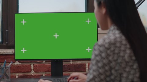 Close up of worker using computer with horizontal green screen in company office. Business woman working with isolated template and mockup background on chroma key monitor. Startup employee