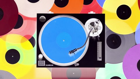 Overhead spinning shot of DJ turntables with different coloured records on the floor 